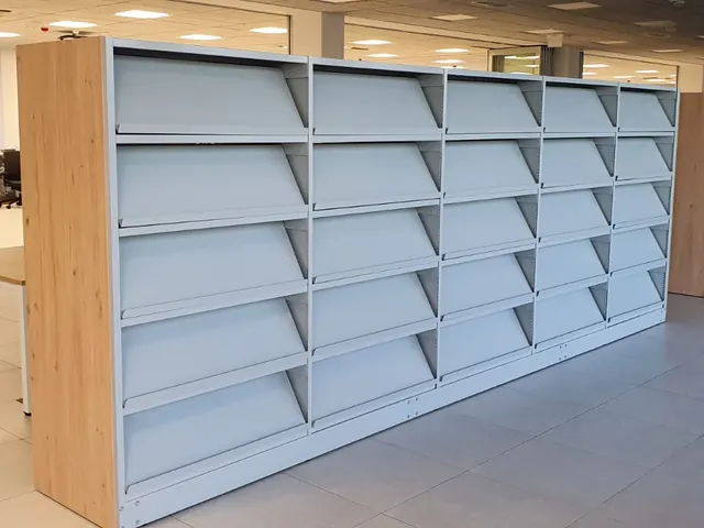 Aydınlık iç mekânda alçak kütüphane rafları